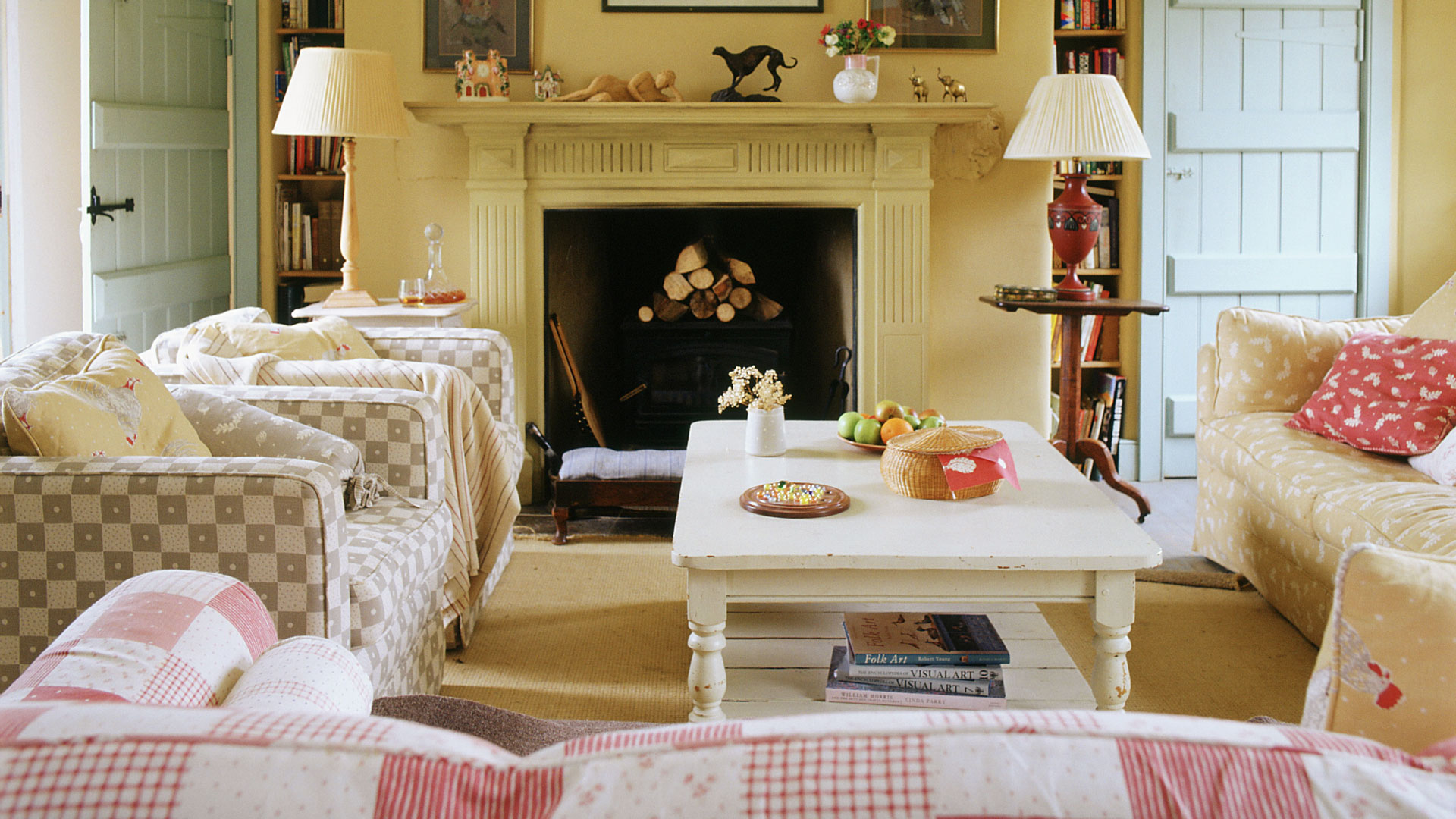 Yellow drawing room with open fire place with patterned sofas either side