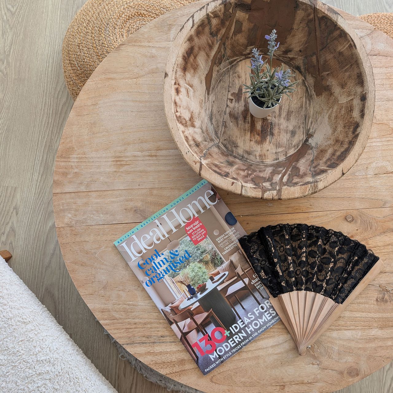 Copy of Ideal Home magazine beside black lace fan on wooden coffee table
