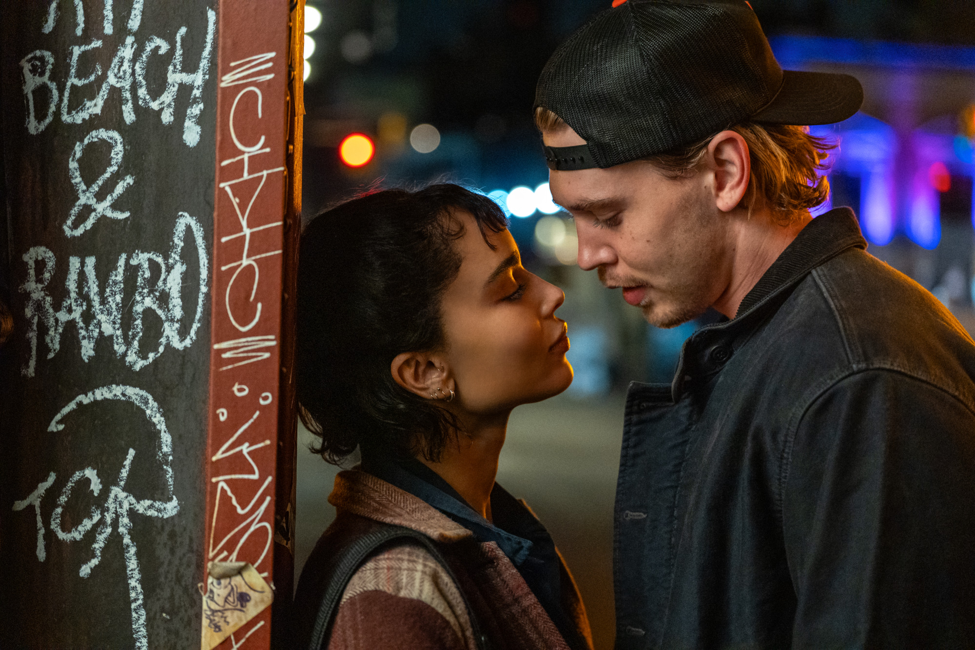 zoe kravitz and austin butler lean in for a kiss while leaning next to a graffeti wall in caught stealing