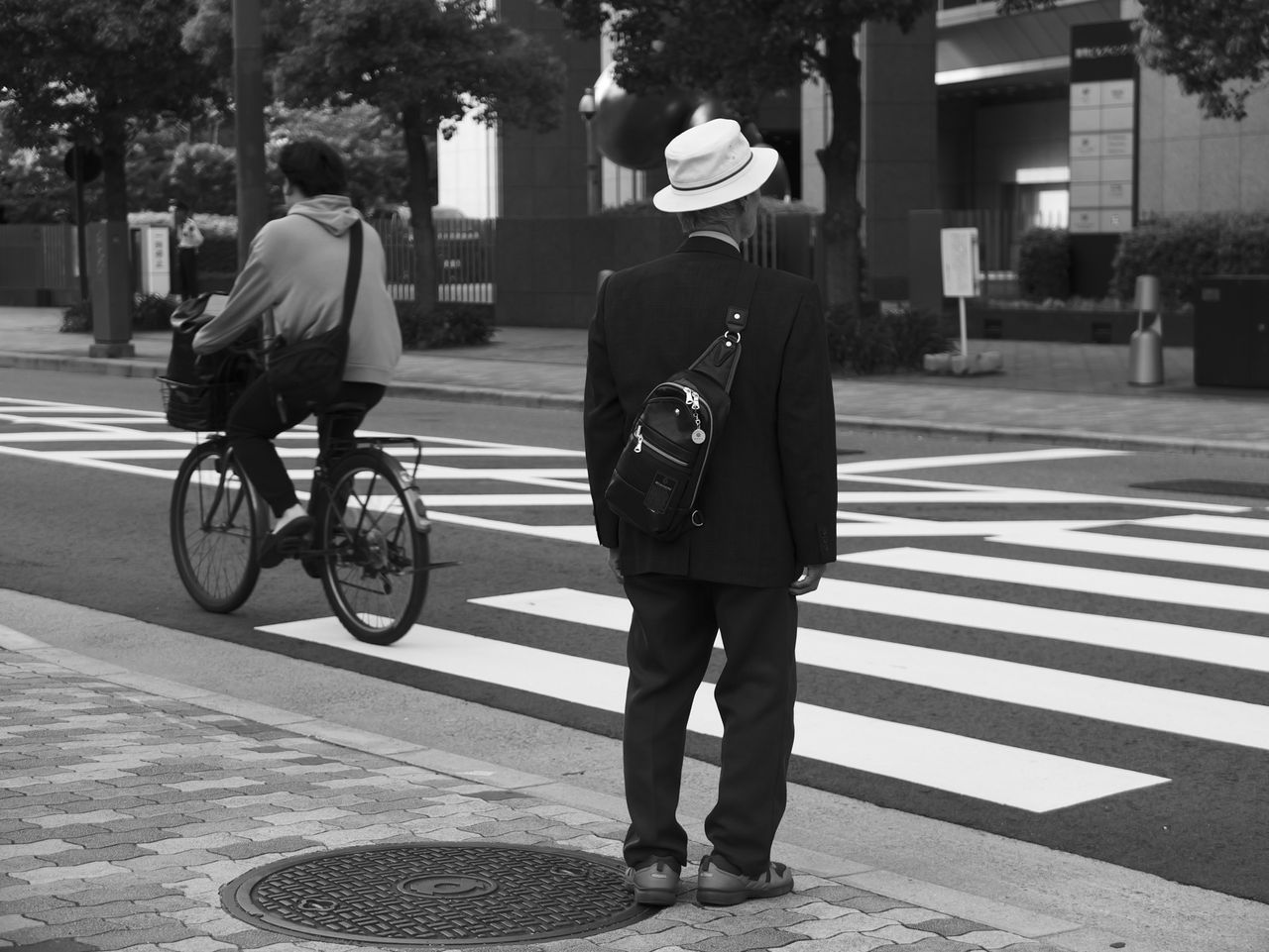 Man waiting at a pedestrin crossing in an urban setting in Japan