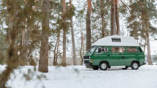 A camper van in a snowy forest