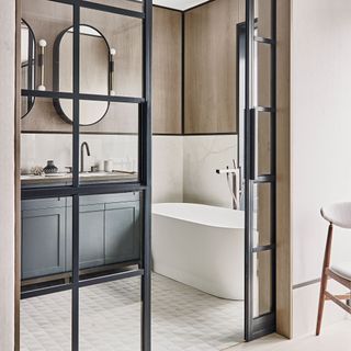 bathroom with white bathtub mirror and grey cabinet