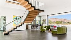 living room with stairs and green sofas and view of mountains