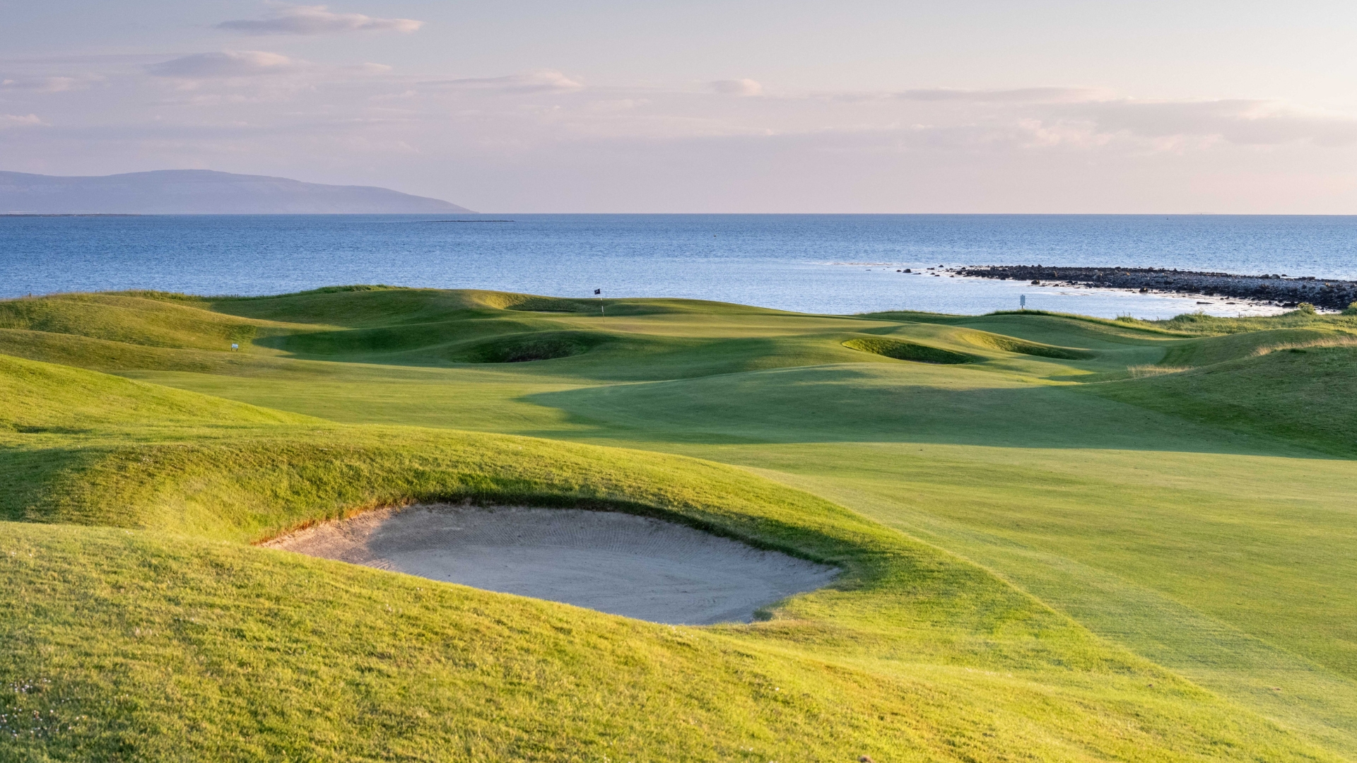 A golf hole with the sea in the background