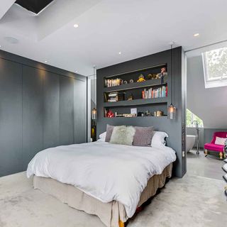 bedroom with grey wall and bed with pillows
