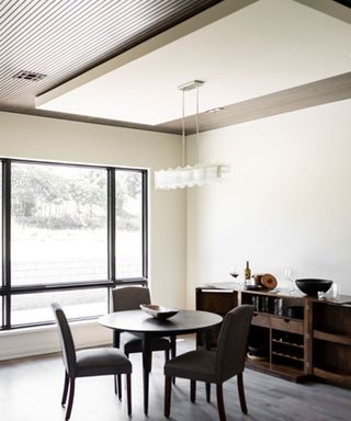 Modern dining area with ceiling elevation and pendant light
