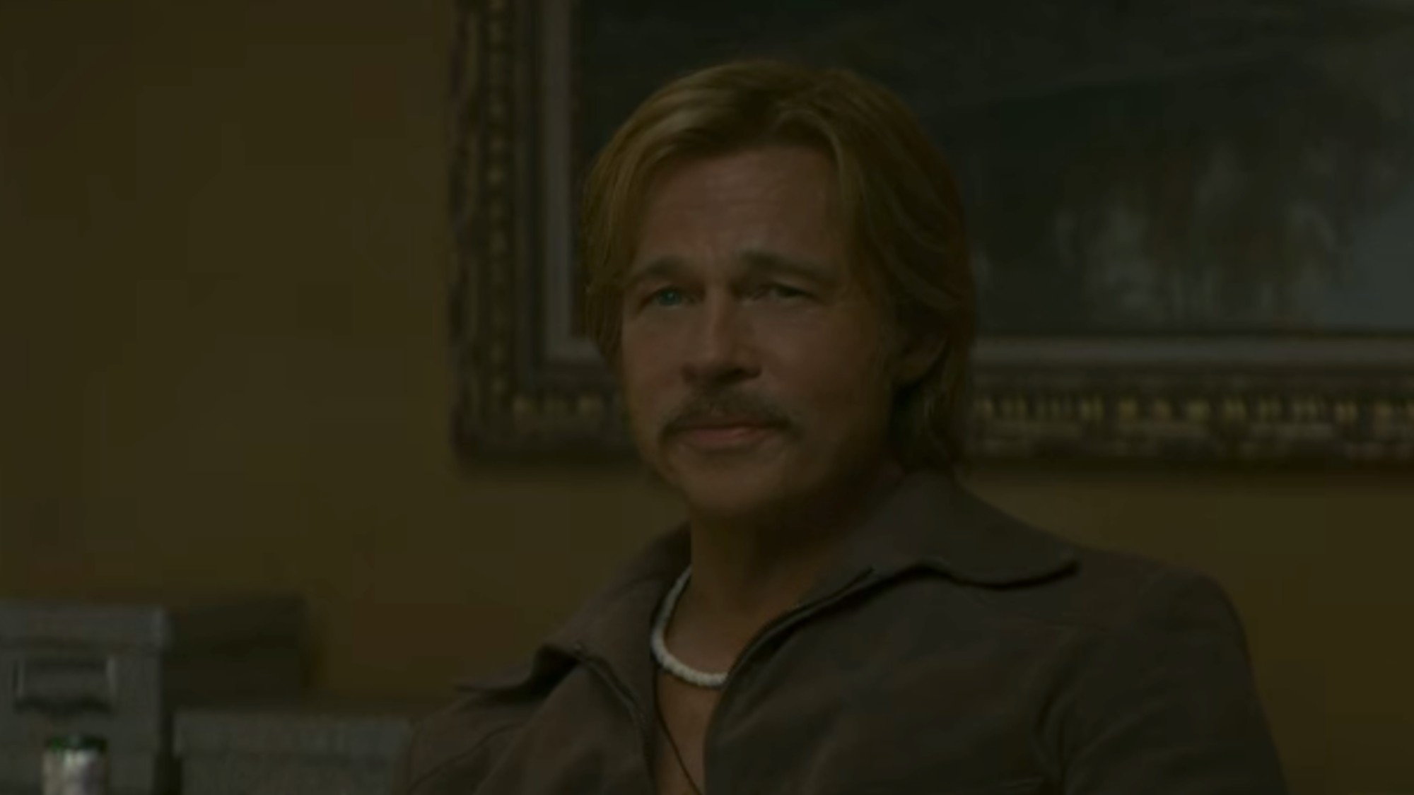 Brad Pitt with a mustache and smiling in The Further Mis-Adventures of Cliff Booth