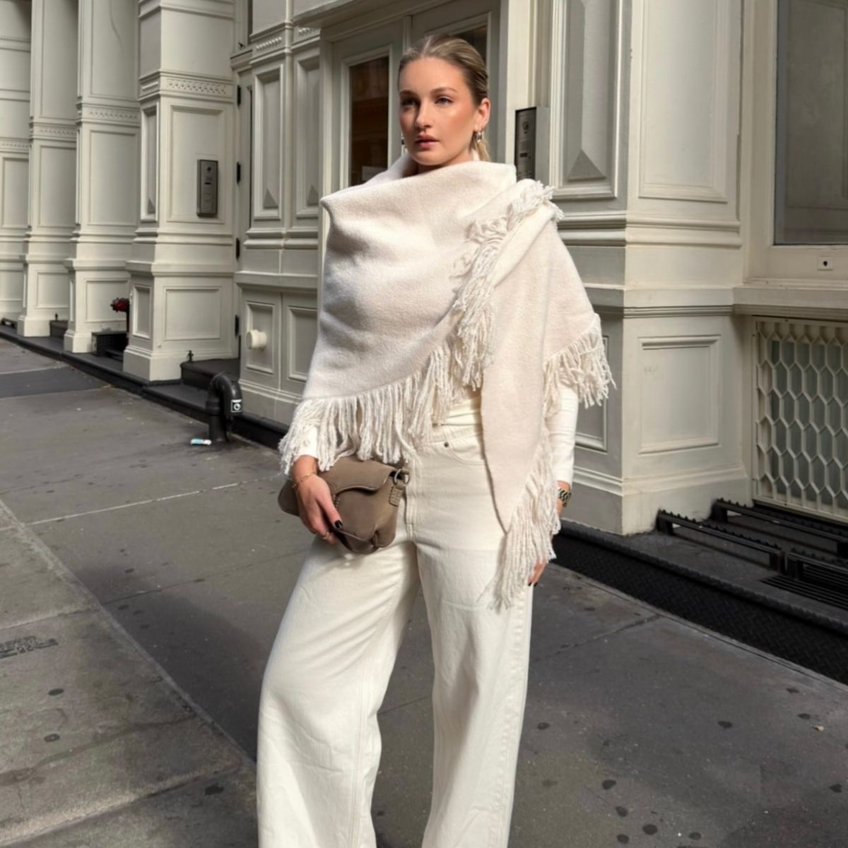 A woman in New York in a chic all-white winter outfit