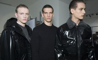 Male models wearing black cloak, black wool overcoat and modern black leather jacket with a wool collar from A/W 2015 Calvin Klein Collection.