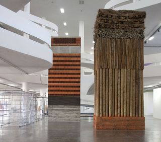 Lais Myrrha’s Dois pesos, duas medidas, 2016, which roughly translates as ’double standard’, consists of two monumental towers – one in industrial construction materials like bricks and cement, the other in indigenous materials like straw and mud. Courtesy Bienal de São Paulo and the artist