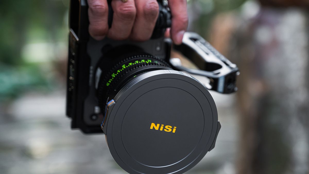 Hand holding camera with NiSi JetMag Pro Filter System lens cap on lens