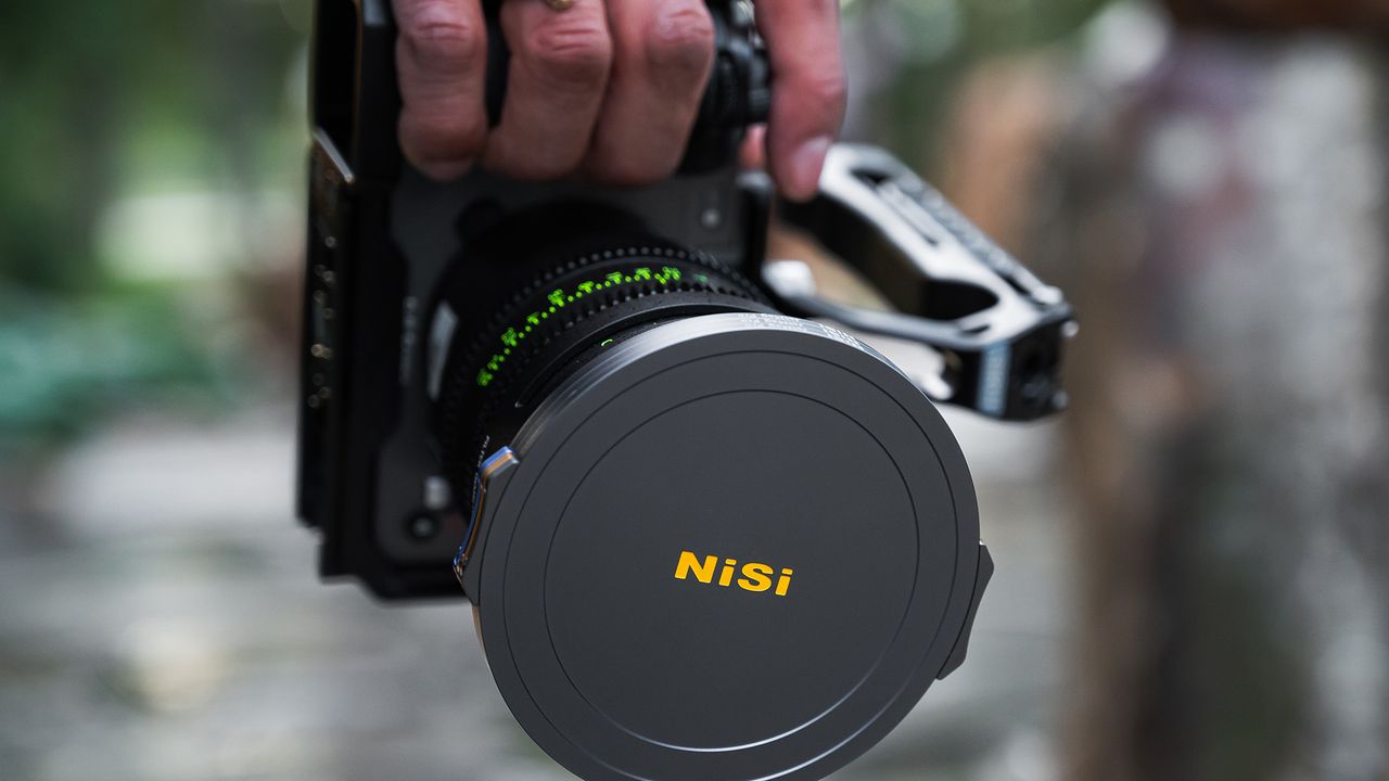 Hand holding camera with NiSi JetMag Pro Filter System lens cap on lens