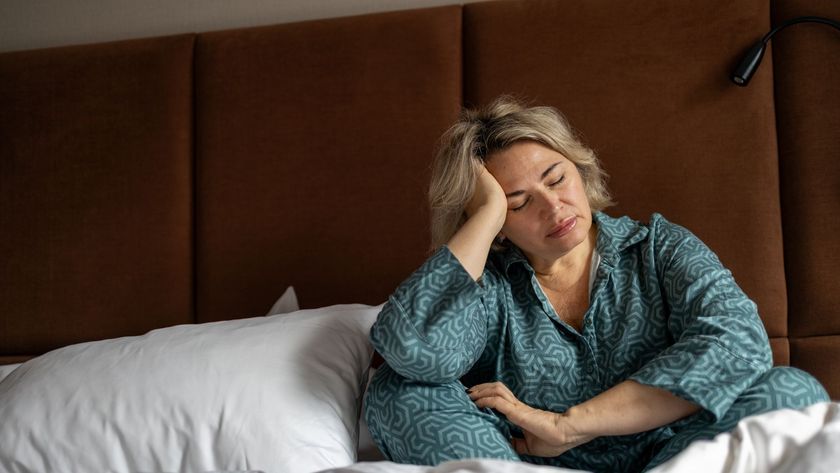 A woman in blue pajamas wakes up at 3am from insomnia. 