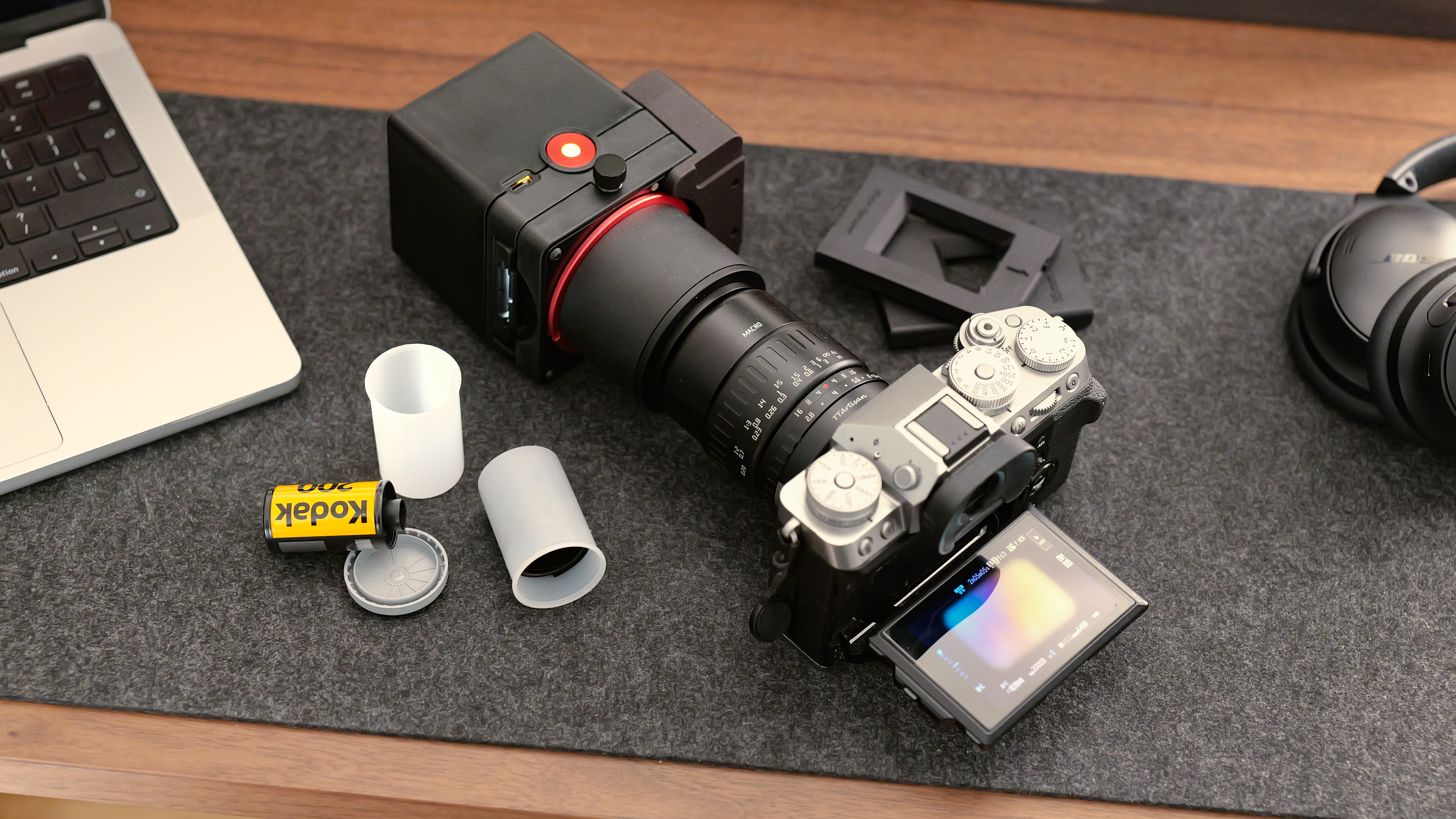 The Valoi easy35 V2 film scanning system mounted to a camera and macro lens, with film canisters and holders beside it.