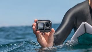 DJI Osmo Action review: a surfer holds the DJI action camera in the water