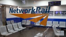 Network Rail logo and branding pictured on a glass partition at a waiting room in London Euston railway station.