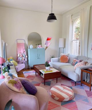 A small living room with a gray couch, coffee table, and colorful decor and furniture