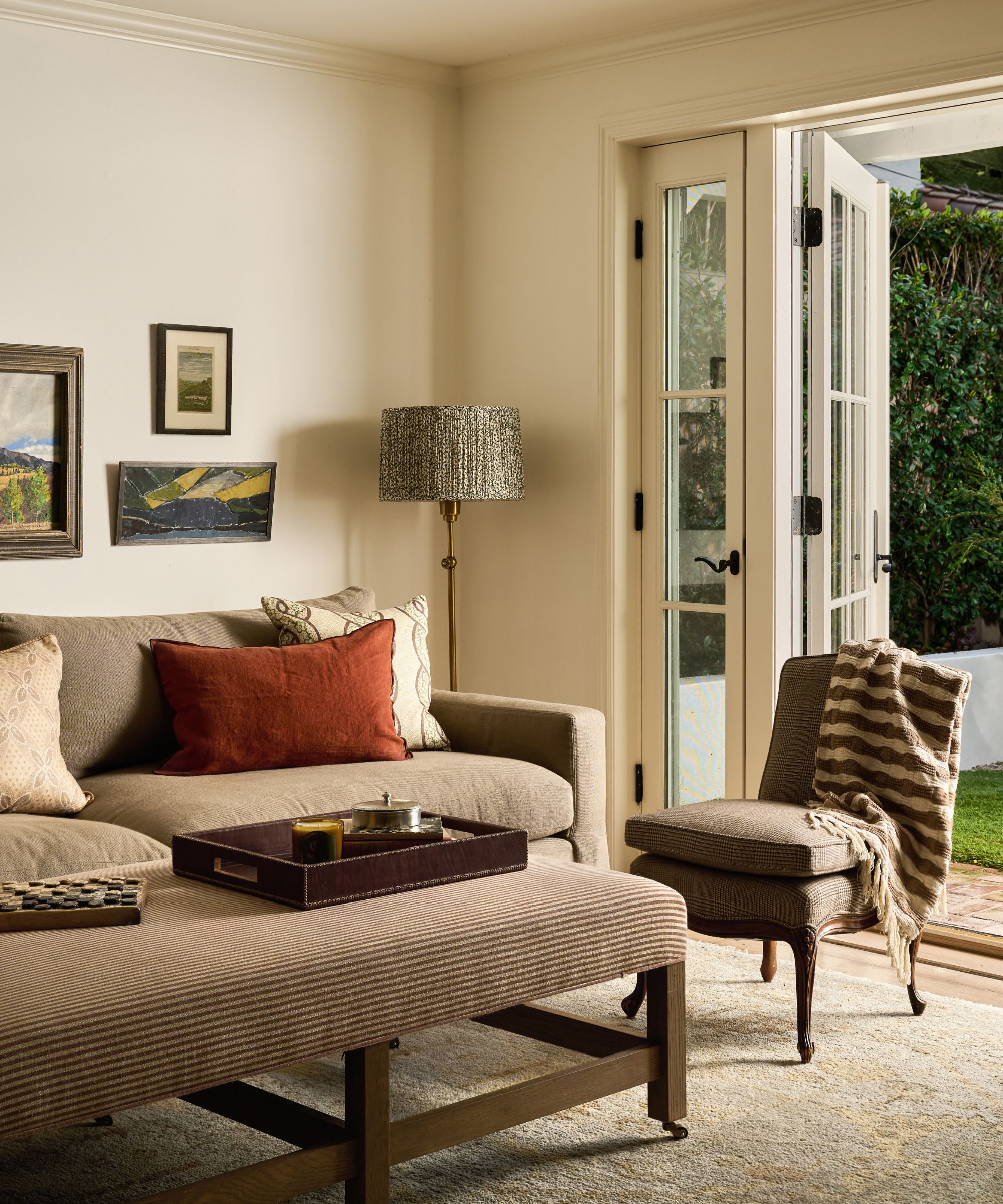 a soft neutral living room with french doors opening to the garden