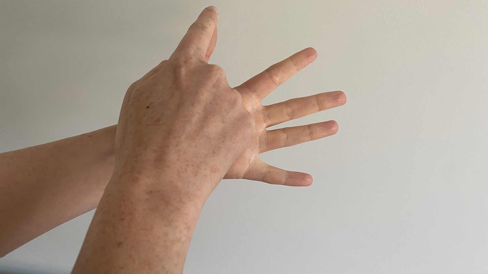 A close up of two hands using the finger breathing relaxation for technique, with the trace finger resting at the tip of the thumb