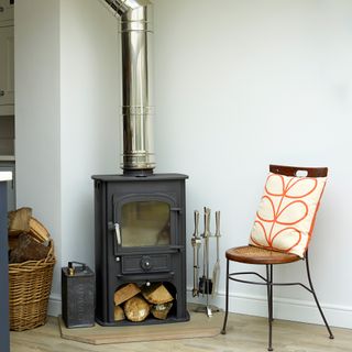 Wood burner with silver chimney in corner of room