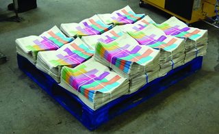 stacks of coloured newspapers on a pallet