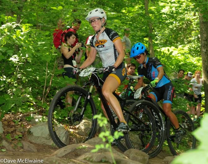 Erin Huck (Tokyo Joes) making a dab on the descent with Evelyn Dong on her wheel