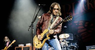 Charlie Starr of Blackberry Smoke wears shades and a brown leather jacket as he plays his TV Yellow Gibson Les Paul Junior live onstage.