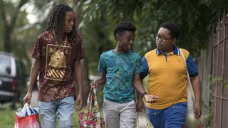 three boys (Michael Epps, Alex Hibbert and Shamon Brown Jr.) carry bags while walking through a tree-lined neighborhood, in the Showtime series 'The Chi'