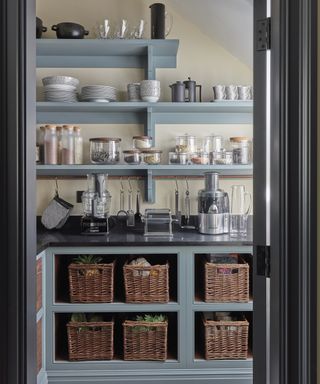 Walk-in pantry ideas with baskets used for shelf storage and appliances along the worktop