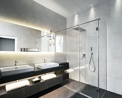 An example of LED bathroom lighting ideas showing a large walk in shower and a double vanity