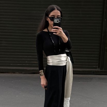 Alexis Badiyi wearing a cummerbund and a black top 