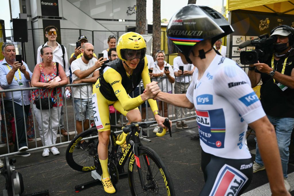 UAE Team Emirates team's Slovenian rider Tadej Pogacar, wearing the overall leader's yellow jersey, shakes hands with Soudal Quick-Step team's Belgian rider Remco Evenepoel prior to take the start of the 21st and final stage of the 111th edition of the Tour de France cycling race, a 33,7 km individual time-trial between Monaco and Nice, on July 21, 2024. (Photo by Marco BERTORELLO / AFP)