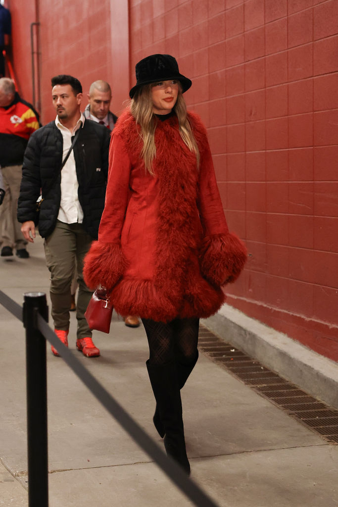 Taylor Swift looks on prior to a game between the Kansas City Chiefs and the Houston Texans wearing red charlotte simone coat