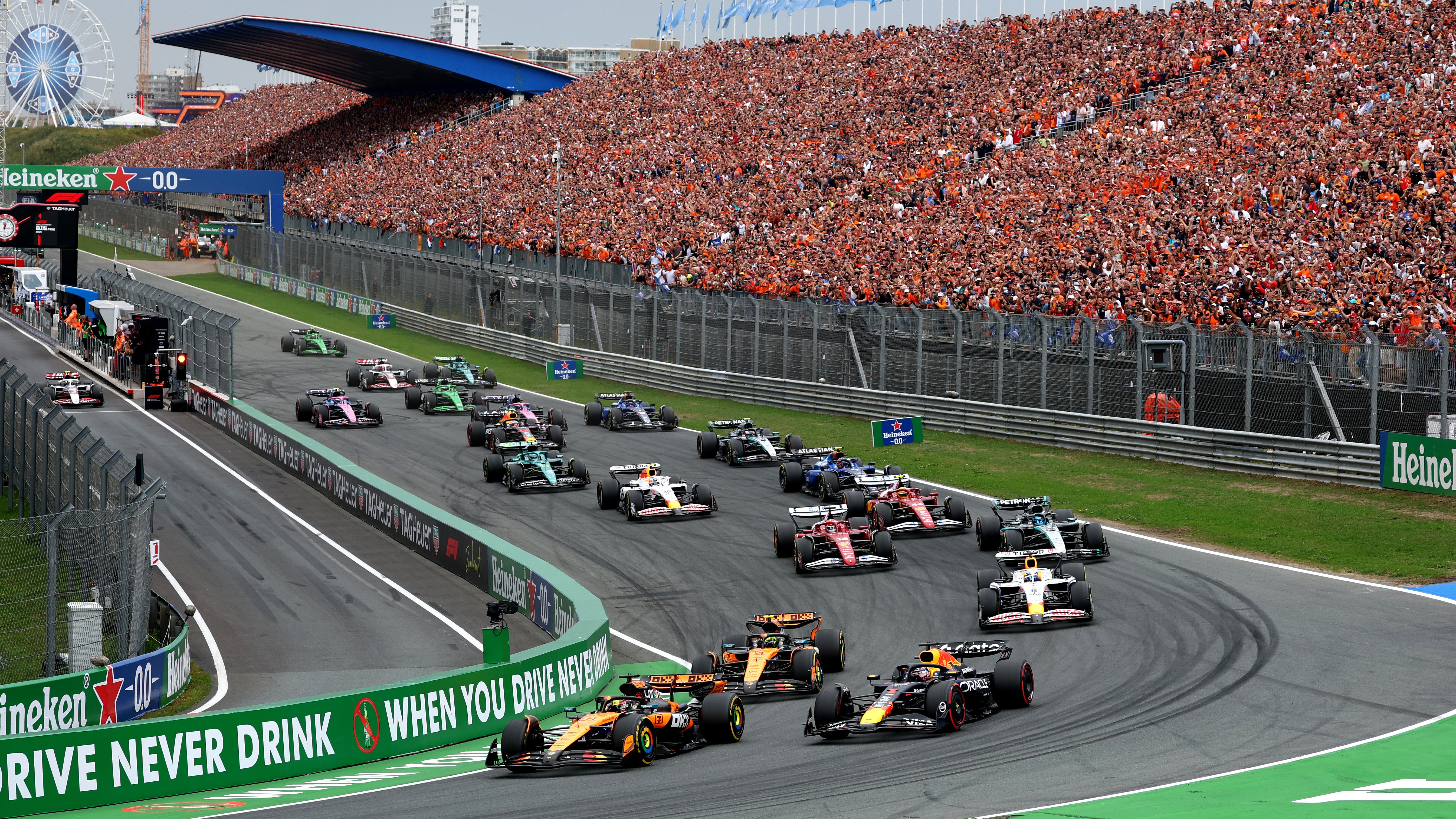 Oscar Piastri of Australia driving the (81) McLaren MCL39 Mercedes and Max Verstappen of the Netherlands driving the (1) Oracle Red Bull Racing RB21 battle for track position into turn 1 at the start during the F1 Grand Prix of Netherlands at Circuit Zandvoort on August 31, 2025 in Zandvoort, Netherlands.