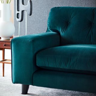 dark green java sofa with table and flower vase