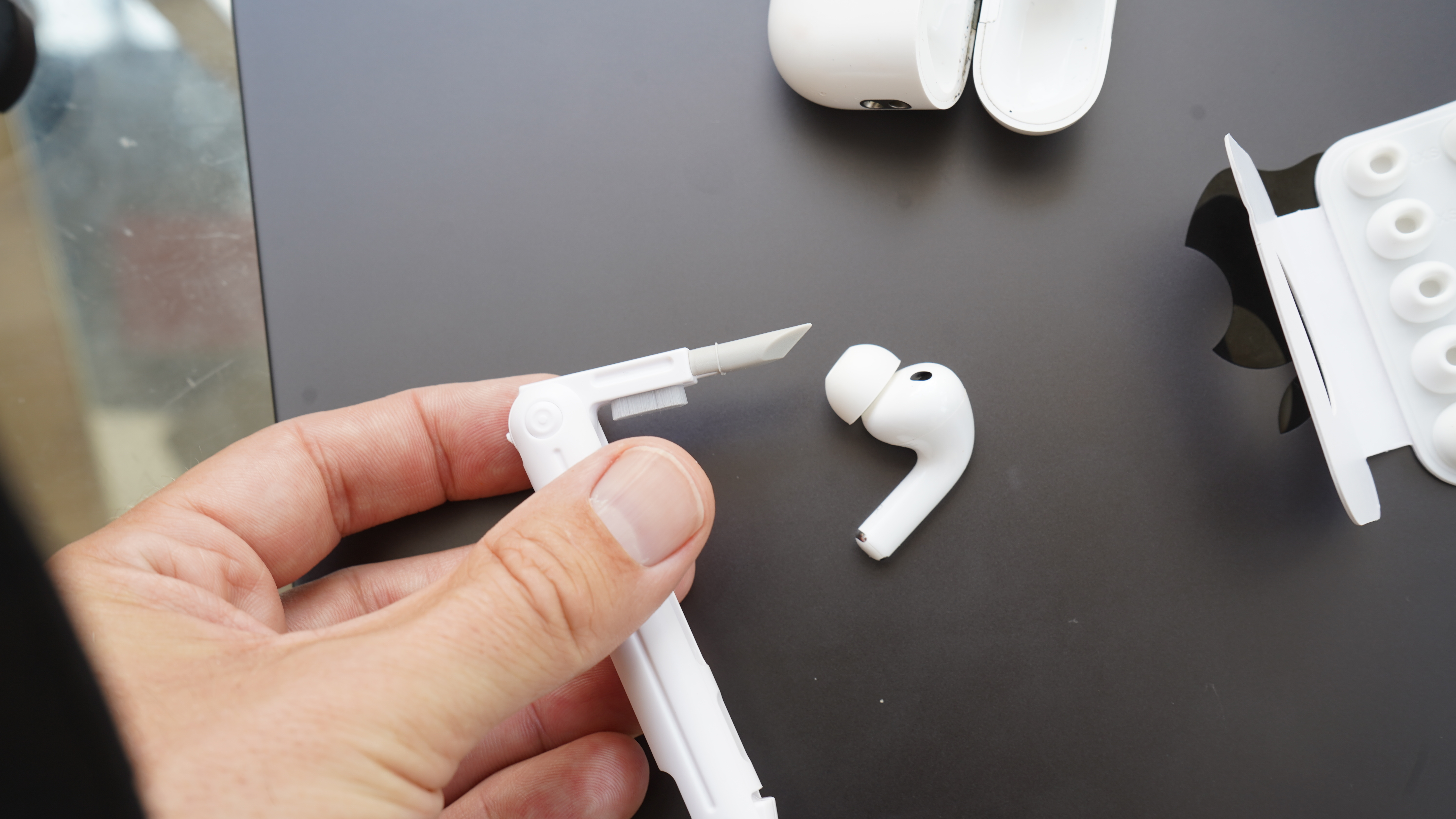 AirPods Pro with cleaning tool in hand
