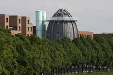 Bonnefanten Museum with dome peeking through trees, a building designed by Aldo Rossi