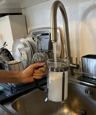 Filling French press glass jug with lukewarm water