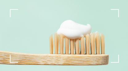 toothbrush with toothpaste on green background