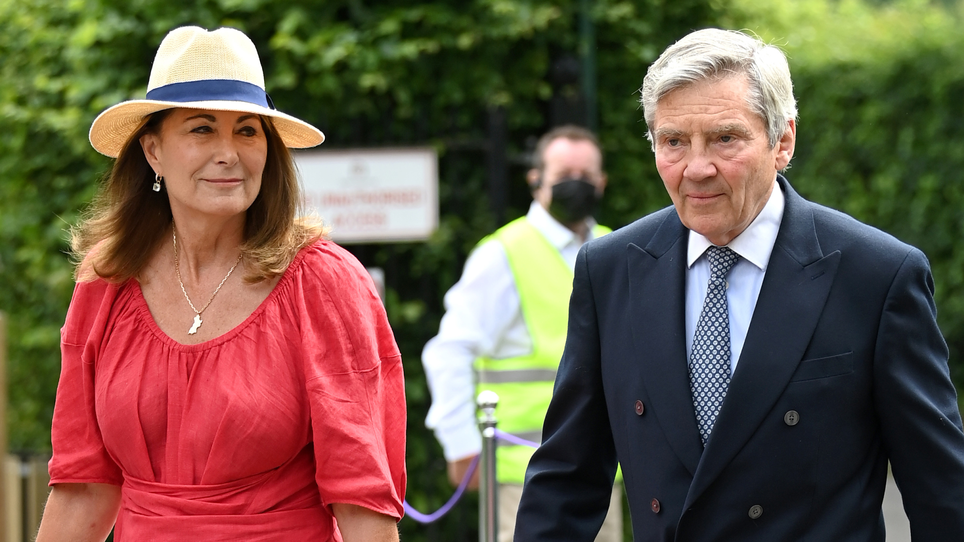Princess Kate's mom Carole Middleton wears a bright red dress and a sun hat to attend Wimbledon Tennis Championships with husband Michael Middleton on July 09, 2021 in London, England