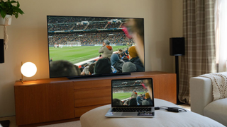 Nyrius Phoenix Prime 4K30 transmitting video of a football match from a laptop to a TV in what looks like a living room