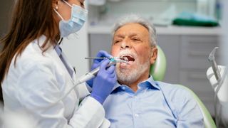 A man with grey hair at the dentist.