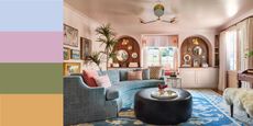 a light pink living room with a light blue sofa and patterned blue rug, with lots of art on the walls