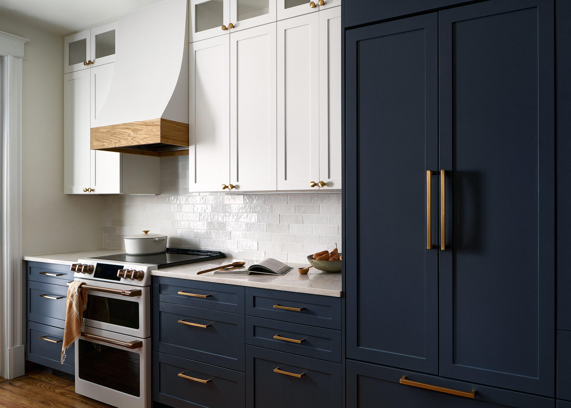 A small kitchen with navy cabinetry and white tiles