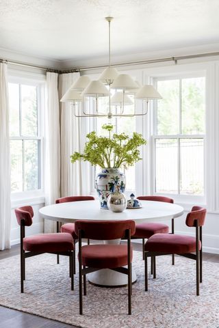 Circular dining table with red velvet dining chairs