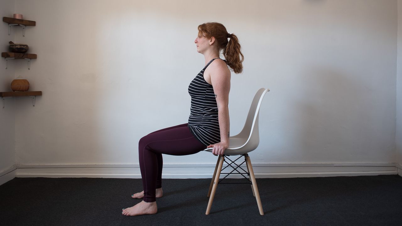 desk exercises: woman in seated posture, using her hands to lift herself forward and up away from the chair seat
