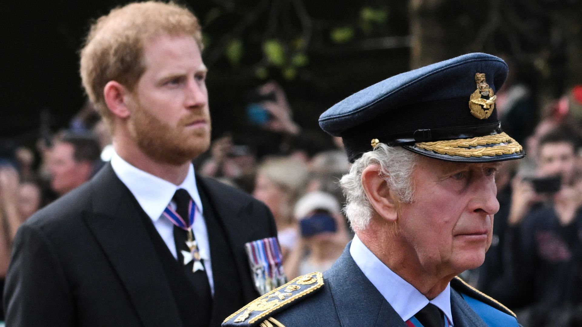 Prince Harry walking behind King Charles III at the funeral of Queen Elizabeth II