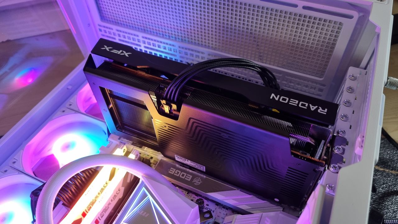 The XFX Swift AMD RX 9060 XT 16 GB in a gaming PC, lit up in blue, yellow and pink