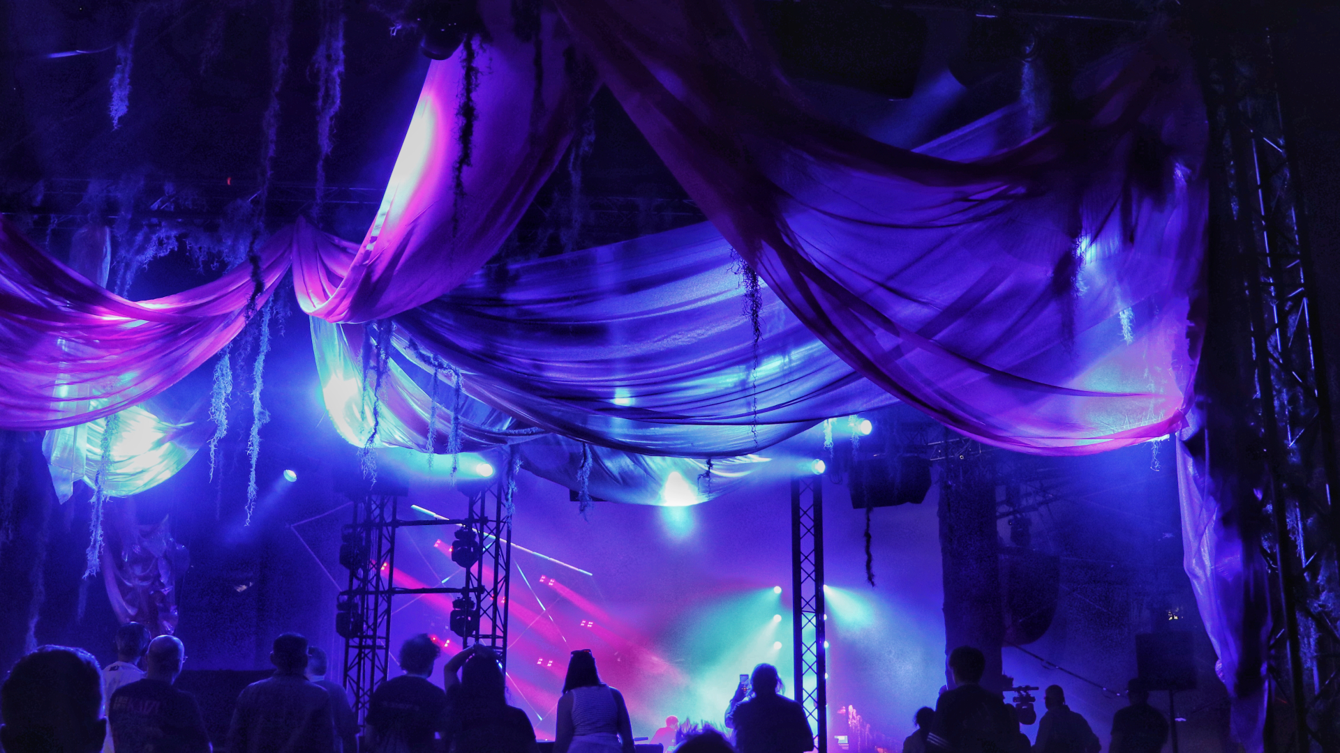 A shot of a VIP area at a concert with pink and blue lighting
