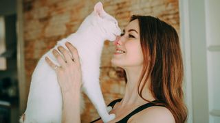 White cat licking lady's nose